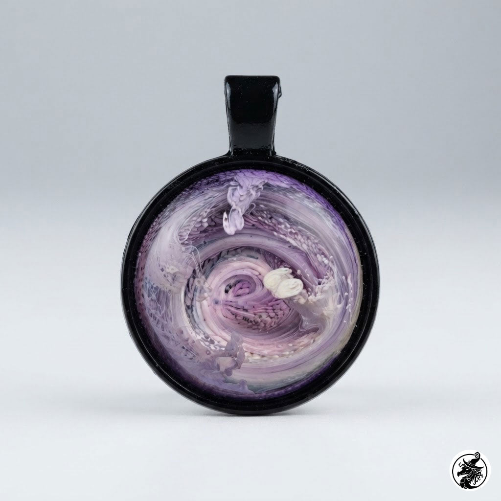 A round pendant with a black handle and a glossy black rim, featuring a purple and white marbled swirl design with a small white flower motif, shown on a light gray background.