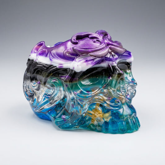 The Dragonsteins Monster Resin Skull by GorgeousDragon Designs LLC. is a desk organizer crafted from recycled artisan resin, featuring swirling purple, white, black, teal, and gold accents with ornate patterns on a smooth gray-to-white gradient background.