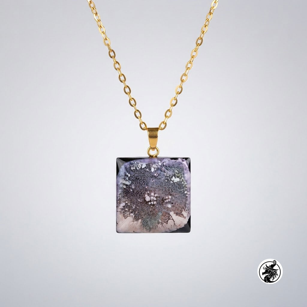A gold chain necklace with a square pendant featuring a detailed, textured tree illustration in shades of purple, gray, and white on a light gray background.