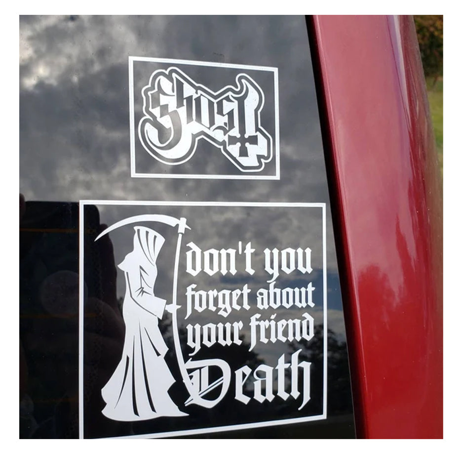 Two white decals on a car window with 'GHOST' and 'Don't you forget about your friend Death'