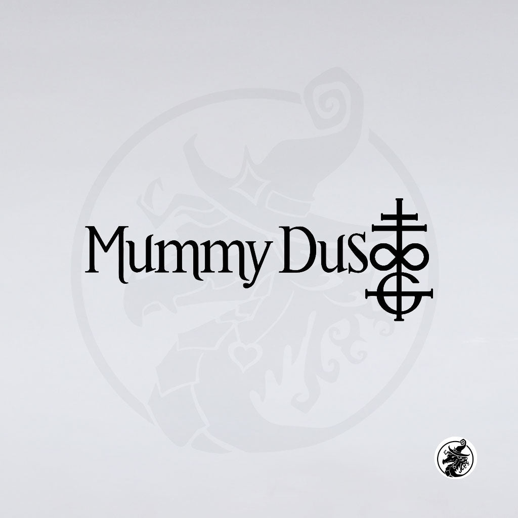 The image showcases "Mummy Dust" in black text with a stylized cross and circle occult symbol to the right, all set on a crisp white background a perfect vinyl decal from GorgeousDragon Designs LLC. for any Ghost band fan.