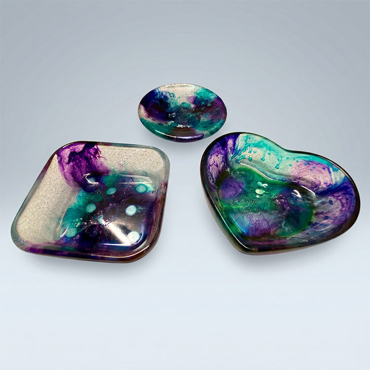 Three colorful resin dishes on a light gray background