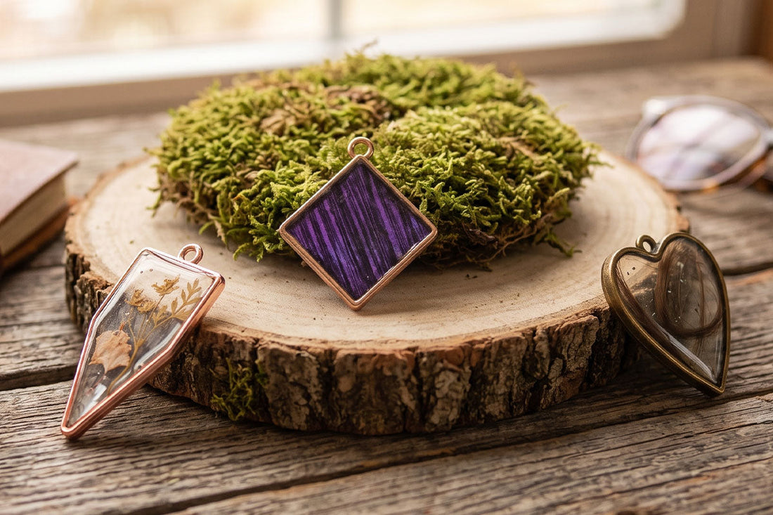 Rose gold and brass terrarium pendants featuring dried flowers, purple wood grain, and moss on a rustic wood slice.