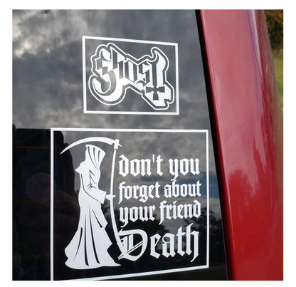 Two white decals on a car window with 'GHOST' and 'Don't you forget about your friend Death'