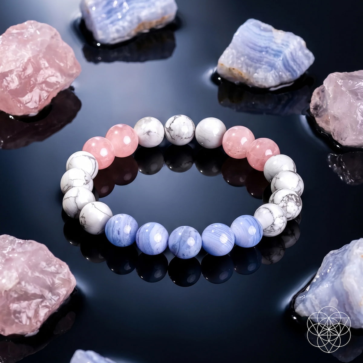 The 3AM Thoughts Off - Deep Sleep Trio Bracelet by Conscious Items, featuring alternating white, pink, and light blue beads for restful sleep, is displayed on a shiny black surface with rough pink and blue crystals; a geometric logo sits at the lower right.