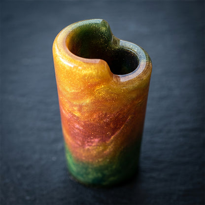 High-angle shot of an empty resin lighter holder showing a gold, orange, and green metallic glitter swirl.