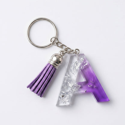 Keychain with purple tassel and letter 'A' charm on a white background