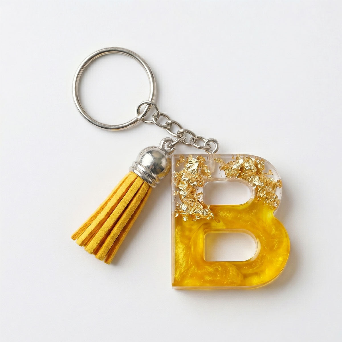 Keychain with yellow letter 'B' and tassel on a white background
