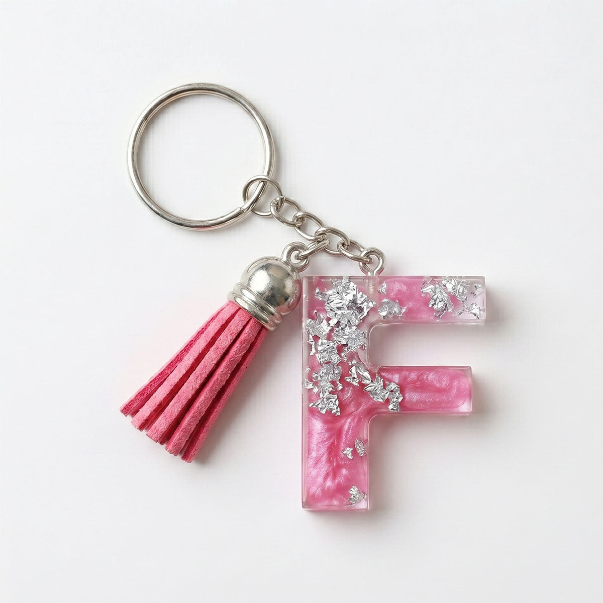 Keychain with pink letter 'F' and tassel on a white background