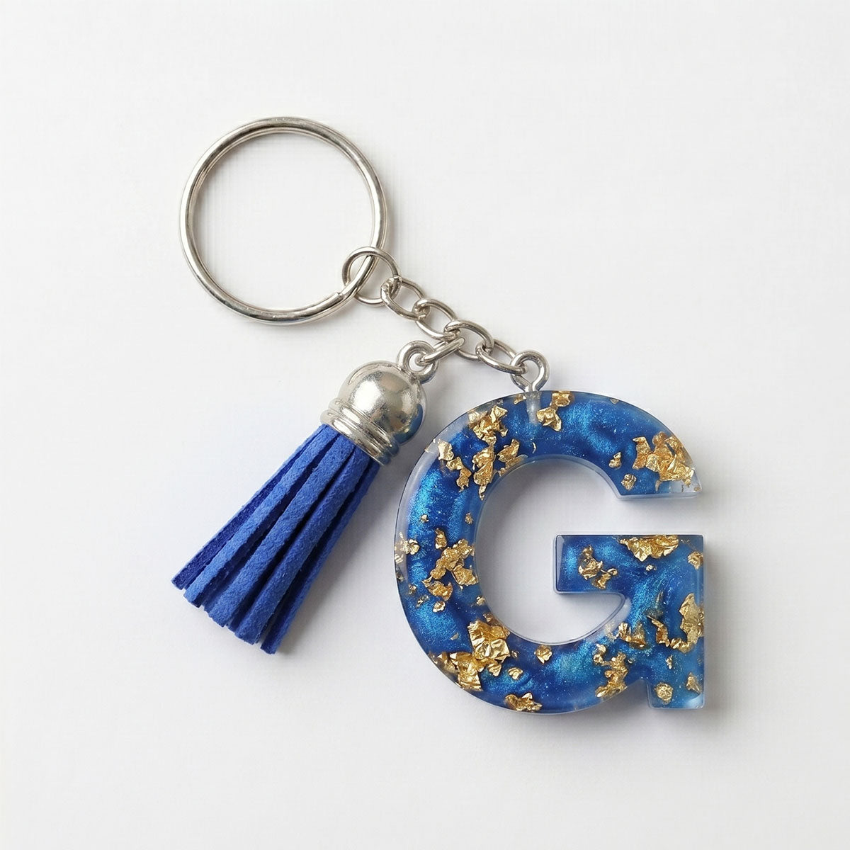 Keychain with blue letter 'G' and tassel on a white background