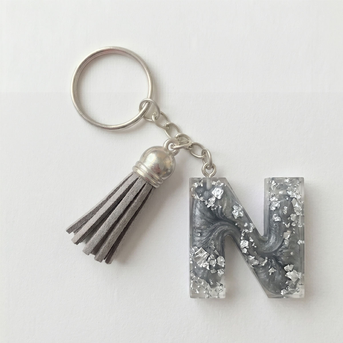 Keychain with letter 'N' and tassel on a white background