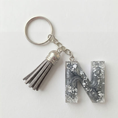 Keychain with letter 'N' and tassel on a white background