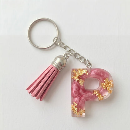 Keychain with pink letter 'P' and tassel on a white background