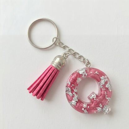 Pink keychain with tassel and decorative element on a white background
