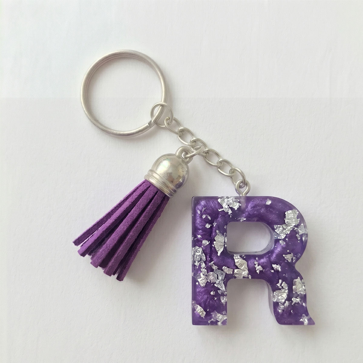 Purple letter 'R' keychain with tassel on a white background