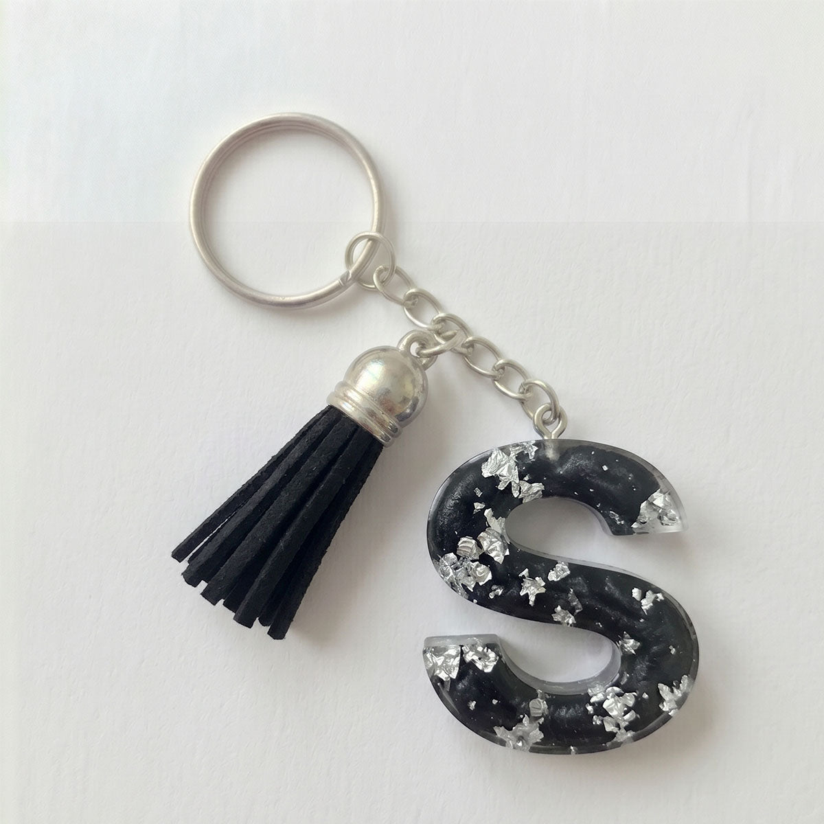 Keychain with letter 'S' and tassel on a white background