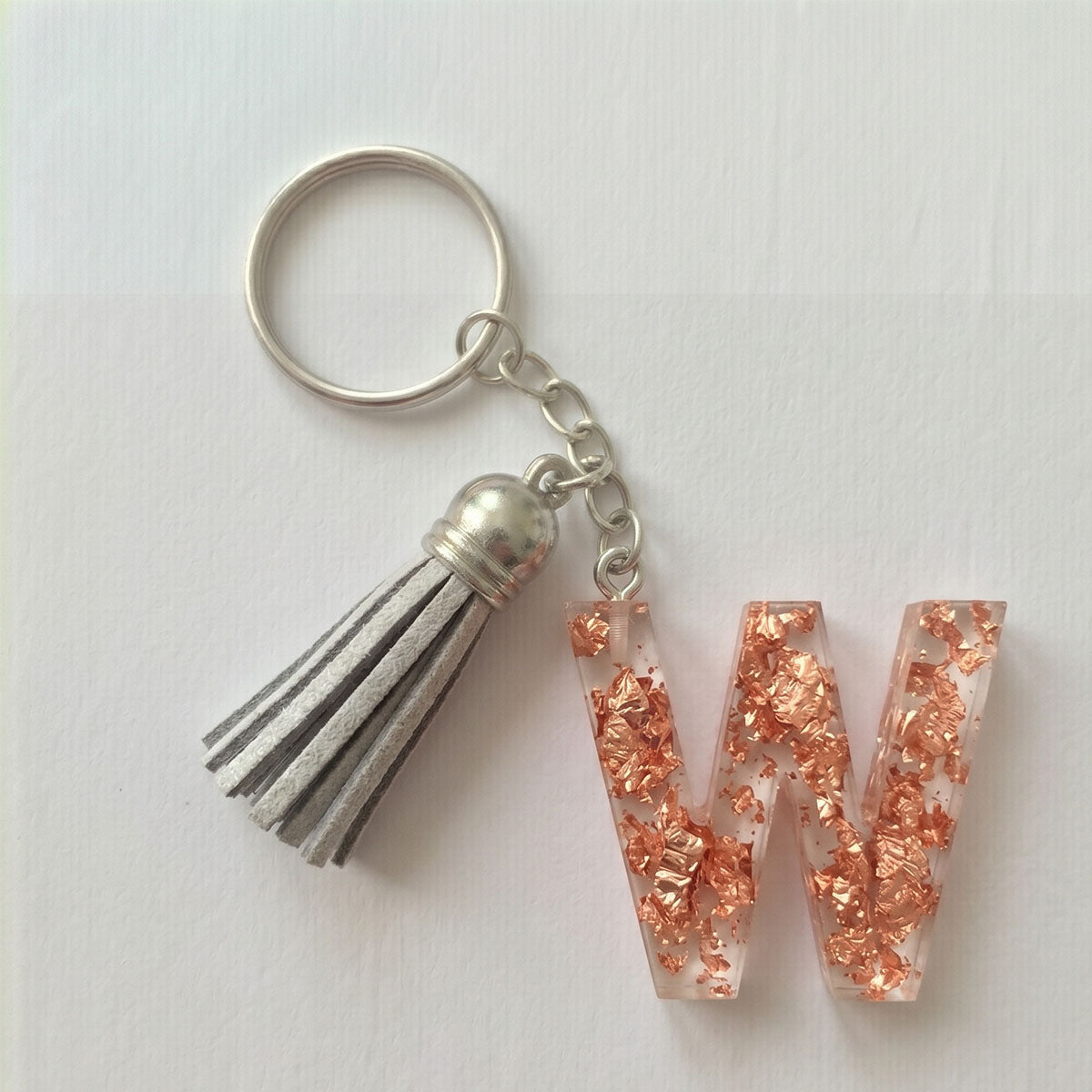 Keychain with letter 'W' and tassel on a white background