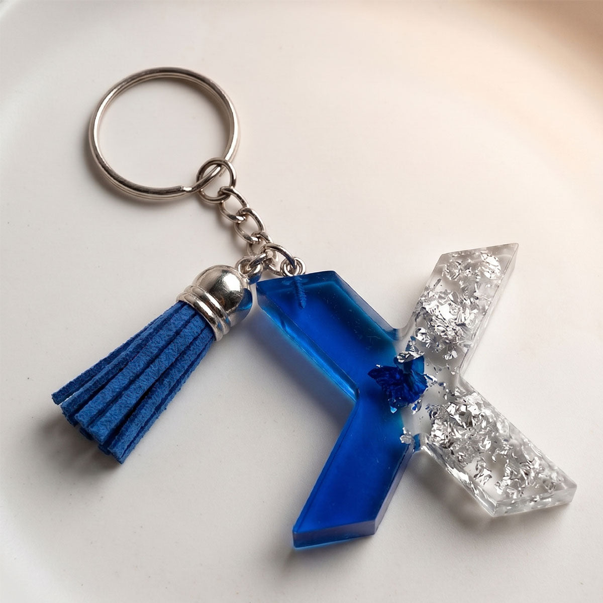 Keychain with blue tassel and geometric shapes on a white background