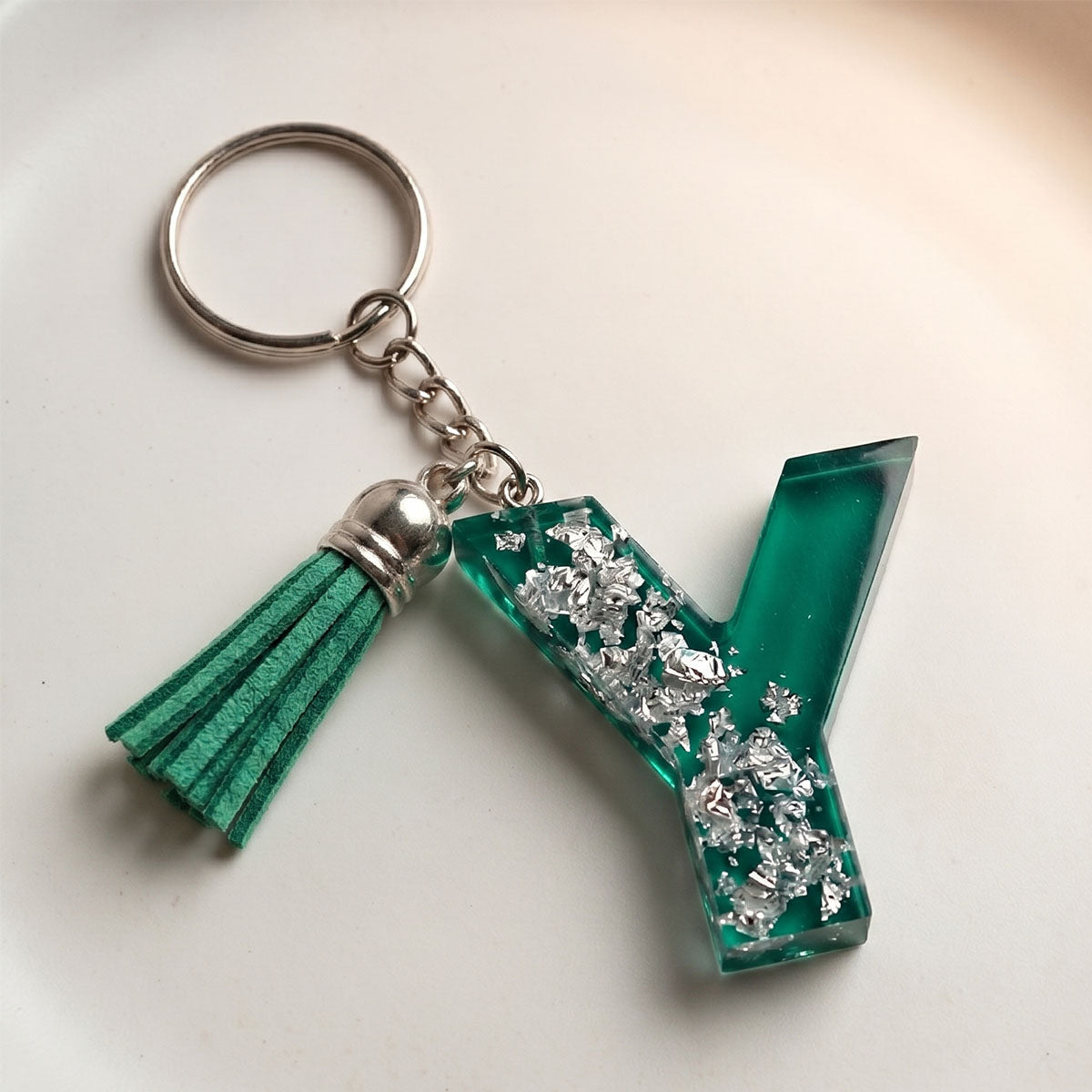 Keychain with green letter 'Y' and tassel on a white background