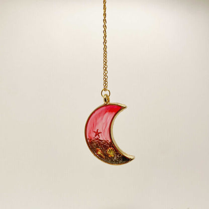 Crescent moon-shaped pendant with star design on a beige background