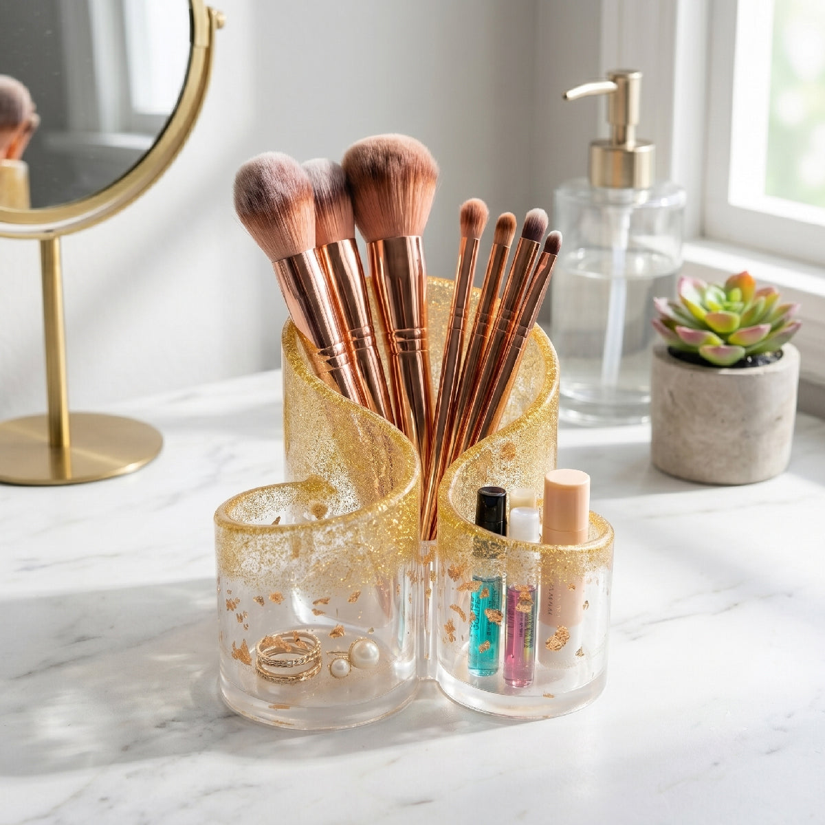 Makeup brushes in a holder on a marble surface with a mirror and plant in the background.