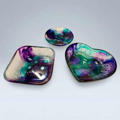 Three colorful resin dishes on a light gray background