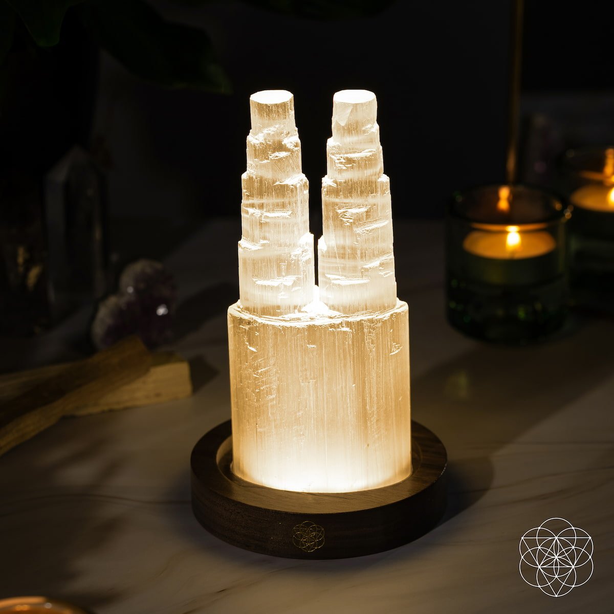 The Two-Tower Selenite Lamp – Deep Energy Cleanse & Reset by Conscious Items features twin crystal towers on a wooden base, ideal for crystal cleansing rituals and adding a soothing glow to your sacred space.