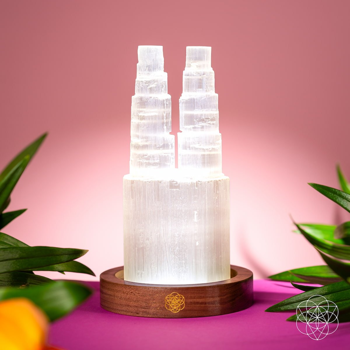 The Conscious Items Two-Tower Selenite Lamp features twin white Moroccan Selenite towers on a round wooden base with a gold geometric design—ideal for deep energy cleansing and resetting any space.