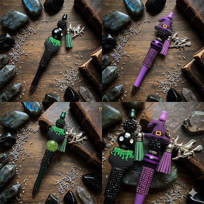 Decorative pens with witch-themed designs on a wooden surface with stones and herbs.